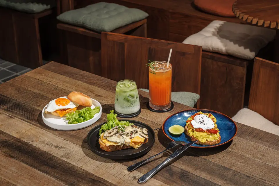Brunch plates and two colorful drinks on a wooden table