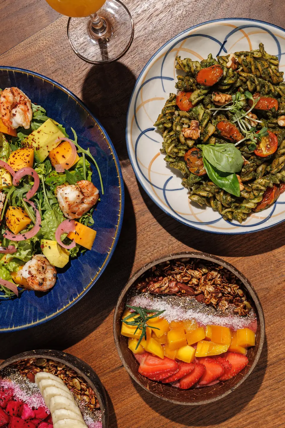 Overhead view of salads and a fruit bowl