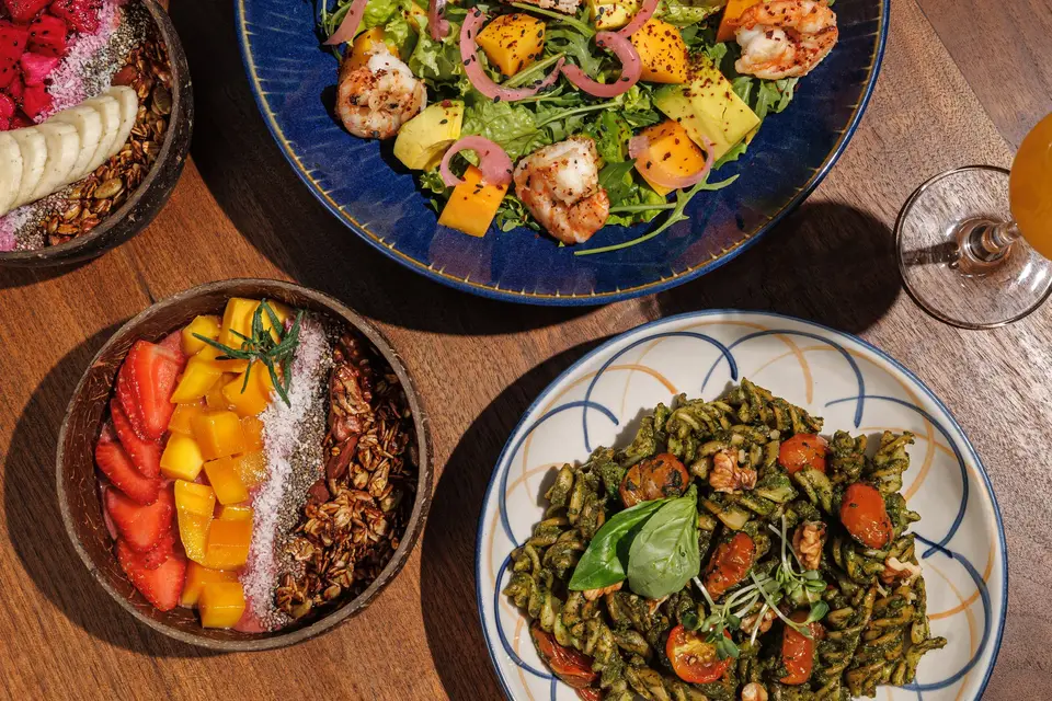 Overhead view of salads and a fruit bowl